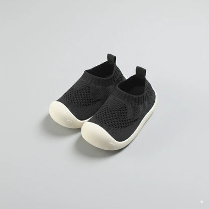 Scarpina primi passi antiscivolo nera in maglia, vista frontale.