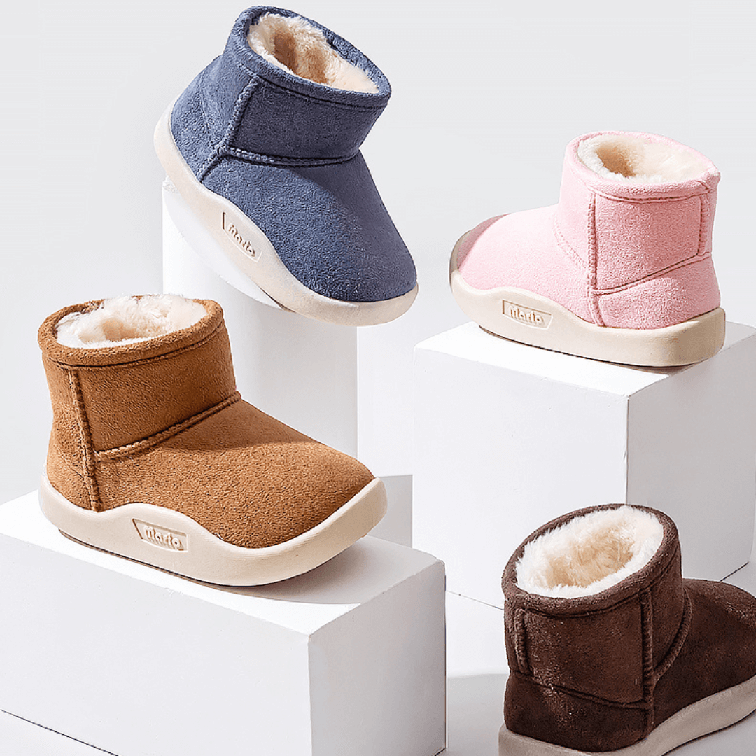 Quattro varianti colore degli stivaletti Snow Boots con fodera calda e suola antiscivolo, vista dall’alto su cubi.